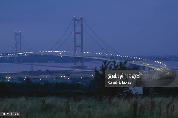 Lights illuminate the Humber Bridge at dusk, Humberside, circa 1985. When the bridge opened to traffic in 1981 it was the largest single span...