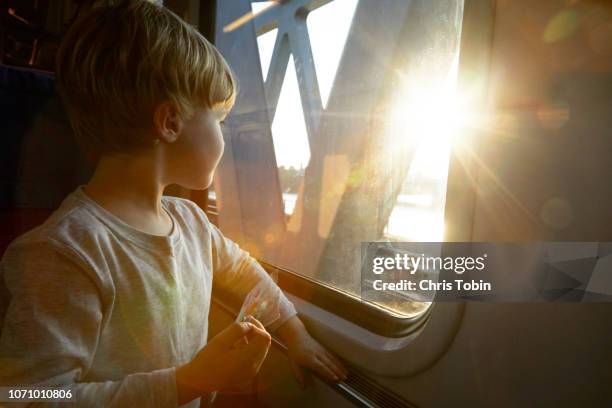 young boy looking out of train window - hamburg germany stock-fotos und bilder