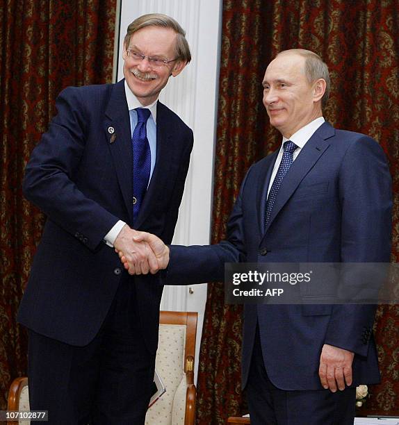 Russian Prime Minister Vladimir Putin shake hands with World Bank President Robert Zoellick on November 23, 2010 during their meeting at the...