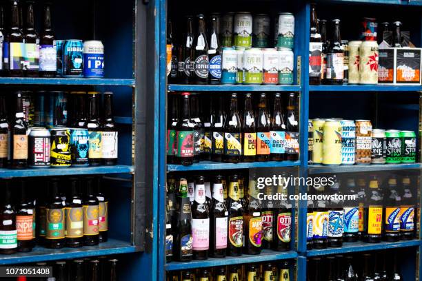 botellas y latas de cerveza real y cerveza artesanal para la venta en el mercado de alimentos y bebidas - craft beer shop fotografías e imágenes de stock
