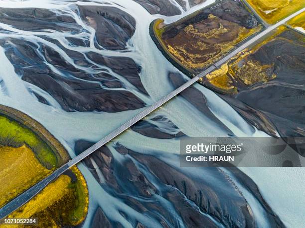aerial view of bridge over braided river. - bridge stock pictures, royalty-free photos & images