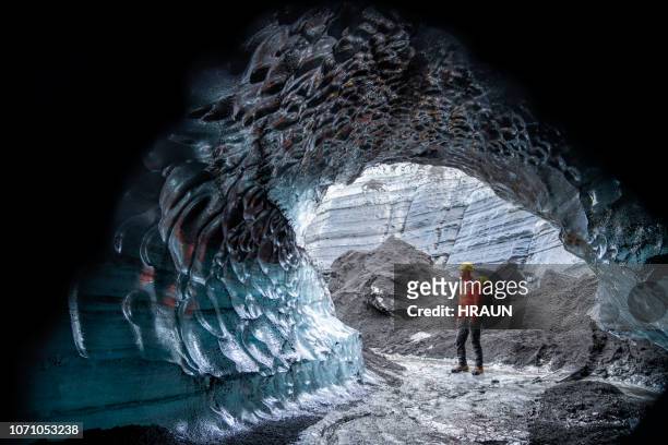 wandelaar permanent door ijsgrot op gletsjer in ijsland - katla volcano stockfoto's en -beelden