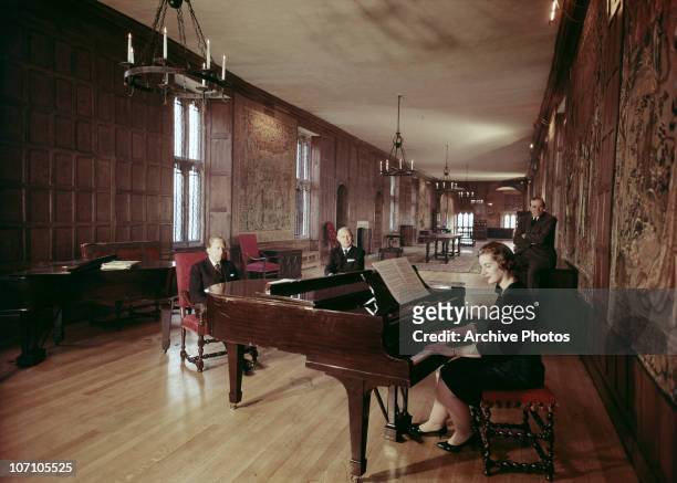 American industrialist J. Paul Getty listens to a piano recital in Sutton Place, his Tudor manor house in Surrey, circa 1960.