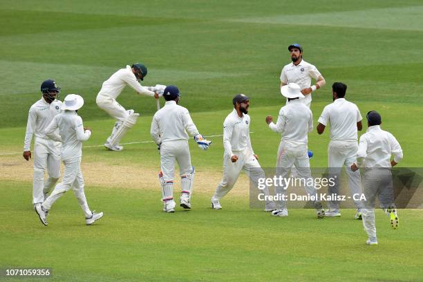 Virat Kohli of India and his team celebrate during day five of the First Test match in the series between Australia and India at Adelaide Oval on...