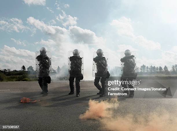 policemen with shields - police in riot gear stock-fotos und bilder