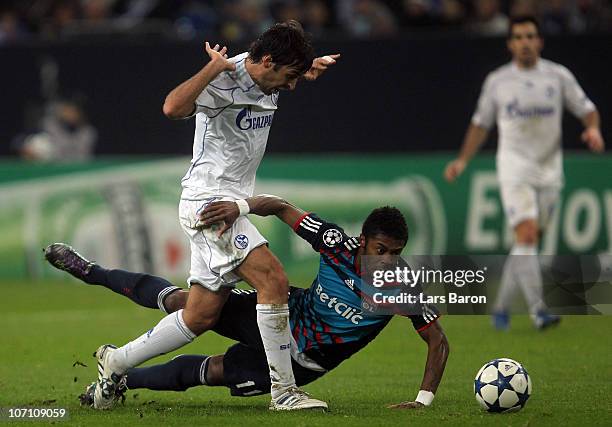 Raul Gonzalez of Schalke challenges Michel Bastos of Lyonnais during the UEFA Champions League group B match between FC Schalke 04 and Olympique...