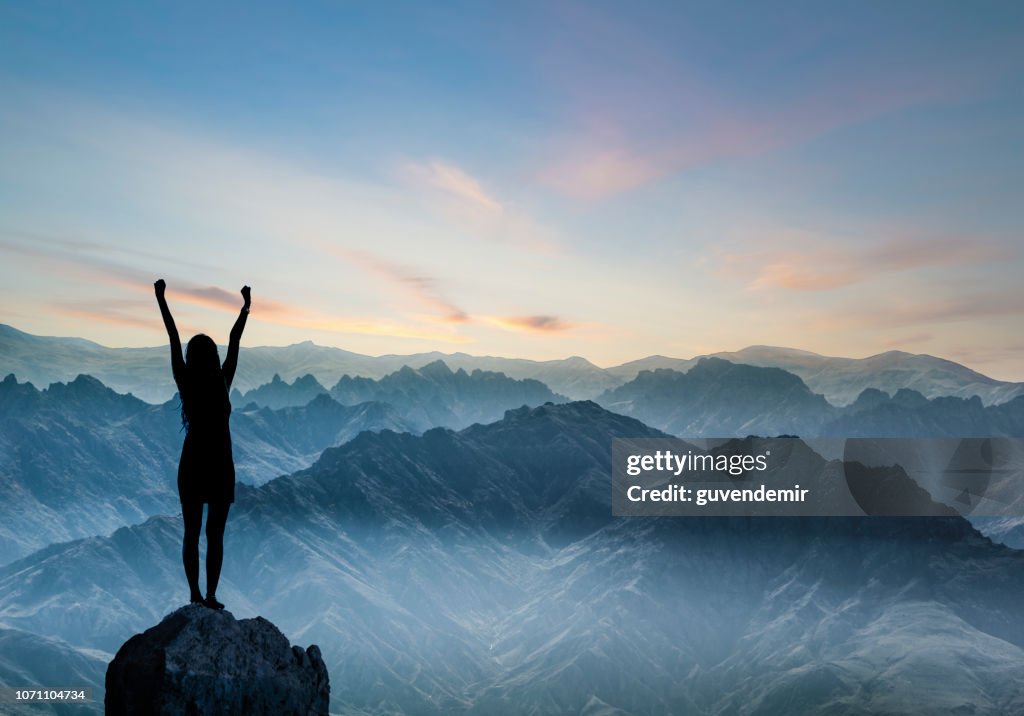Frauen-Silhouette bei Sonnenuntergang auf Hügel