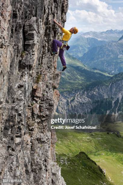 a woman climbs up a vertical rock face, difficulty level 6, angererkopf, mindelheim alpine hut, allgaeu alps, bavaria, germany - escalada libre fotografías e imágenes de stock