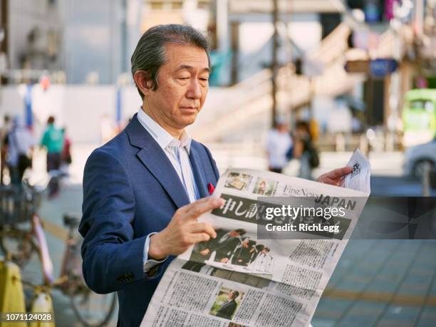 japanischer geschäftsmann mit zeitung - japanese paper stock-fotos und bilder