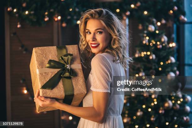 schöne frau mit geschenk - weihnachten geschenke stock-fotos und bilder