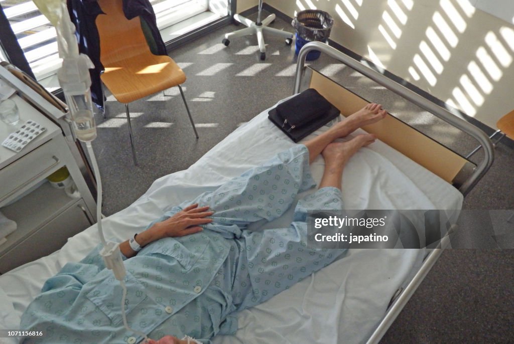Sick woman with a iv drip in her neck to give her medicines