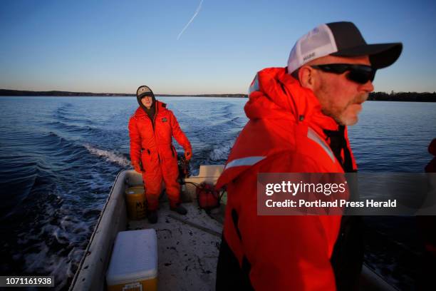 Dan Devereaux, co-owner of Mere Point Oyster Company, and his son Jesse left, check on bouy markers at the company's proposed 40-acre lease in the...