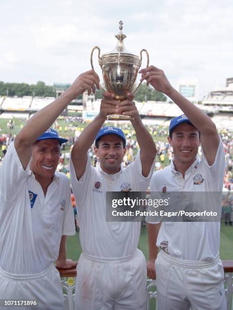 Surrey captain Adam Hollioake , wicketkeeper Alec Stewart and Man of the Match Ben Hollioake hold aloft the trophy after Surrey won the Benson and...