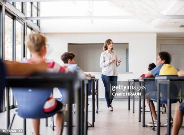 teacher teaching students in classroom - teacher taking attendance stock pictures, royalty-free photos & images