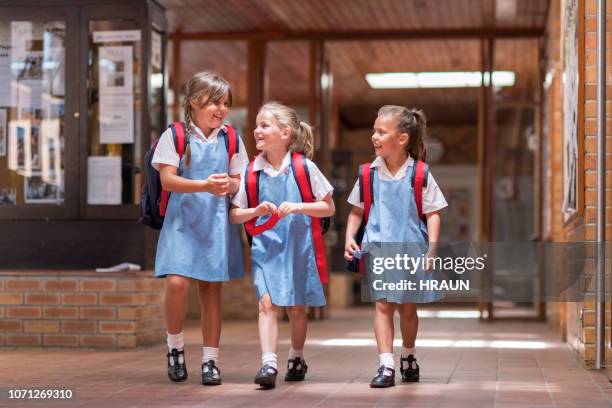 happy cute girls leaving from school - school students uniform walking stock pictures, royalty-free photos & images