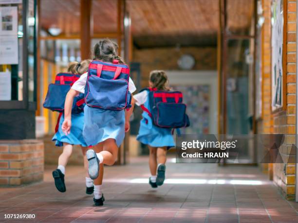 begeistert schüler laufen in richtung eingang - school uniform stock-fotos und bilder