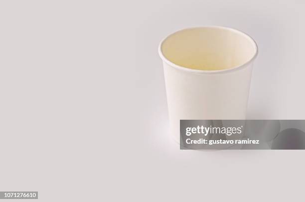 white plastic cup on white background - paper cup fotografías e imágenes de stock