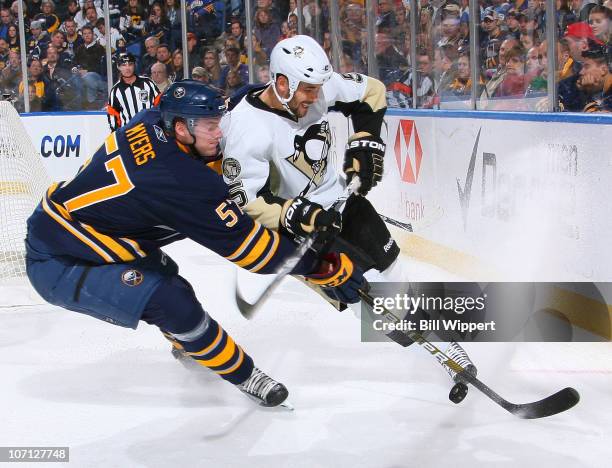 Tyler Myers of the Buffalo Sabres reaches in for the puck against Deryk Engelland of the Pittsburgh Penguins at HSBC Arena on November 24, 2010 in...