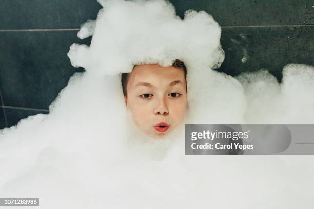boy un bubble bath relaxing - schaumstoff stock-fotos und bilder
