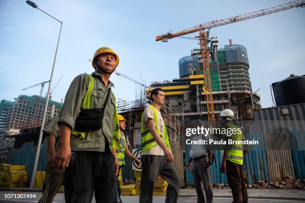 Chinese Construction workers head home after work on site at a new shopping mall called The Mall at One Galle Face which is part of the Chinese...