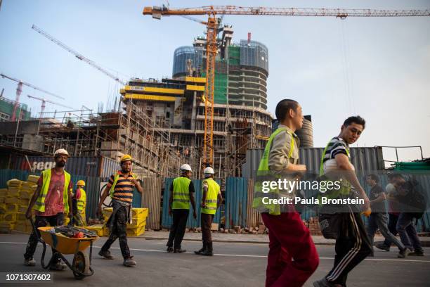 Chinese Construction workers head home after work on site at a new shopping mall called The Mall at One Galle Face which is part of the Chinese...