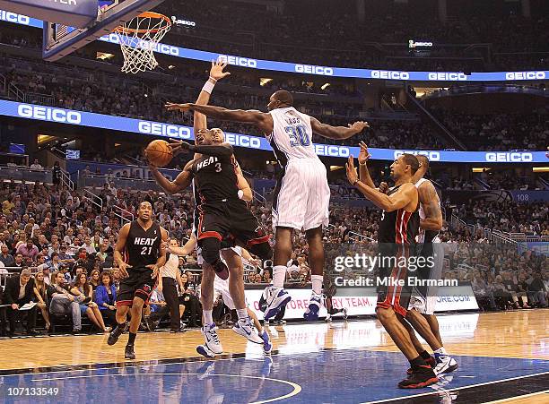 Dwyane Wade of the Miami Heat shoots over Brandon Bass of the Orlando Magic during a game at Amway Arena on November 24, 2010 in Orlando, Florida....