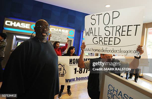 Group of homeowners facing eviction over the holiday period, protest against their plight outside a bank office by eating their Thanksgiving dinner...