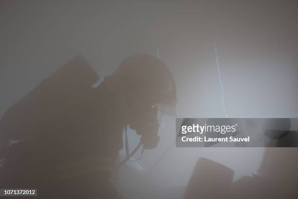 a firefighter at work hidden by smoke - laurent sauvel photos et images de collection