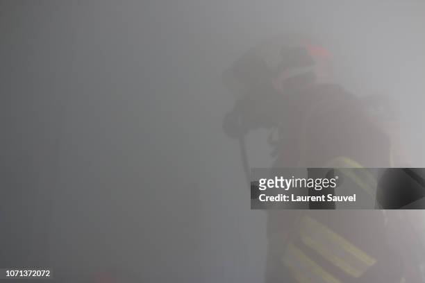 a firefighter at work hidden by smoke - laurent sauvel photos et images de collection