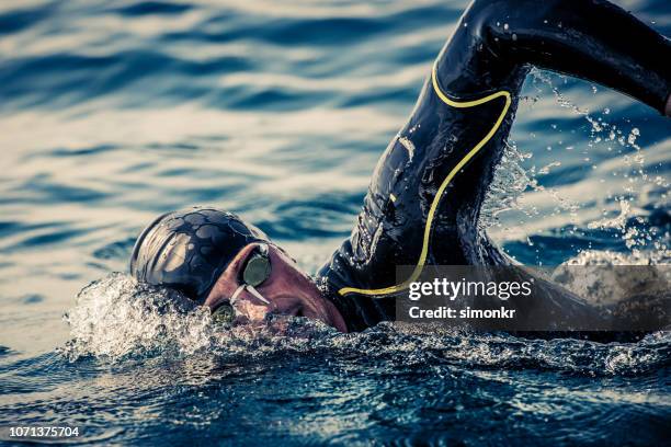 open water swimmer swimming in sea - swimmer athlete stock pictures, royalty-free photos & images