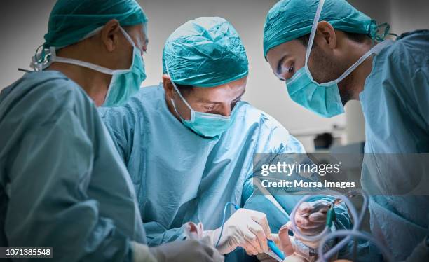 surgeons operating patient for breast implant - operatiekamer stockfoto's en -beelden