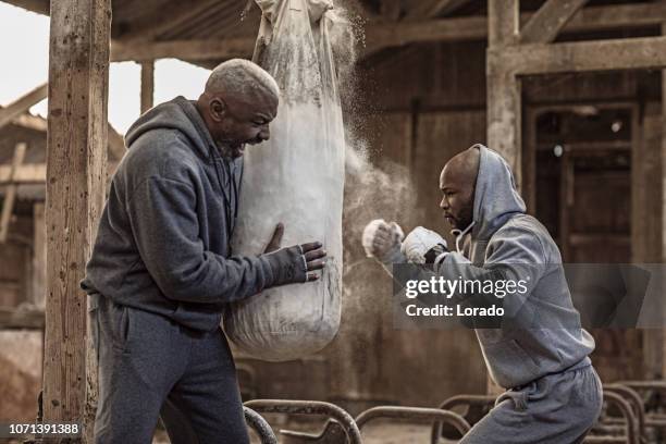 middle aged black coach and young black fighter - boxing trainer stock pictures, royalty-free photos & images