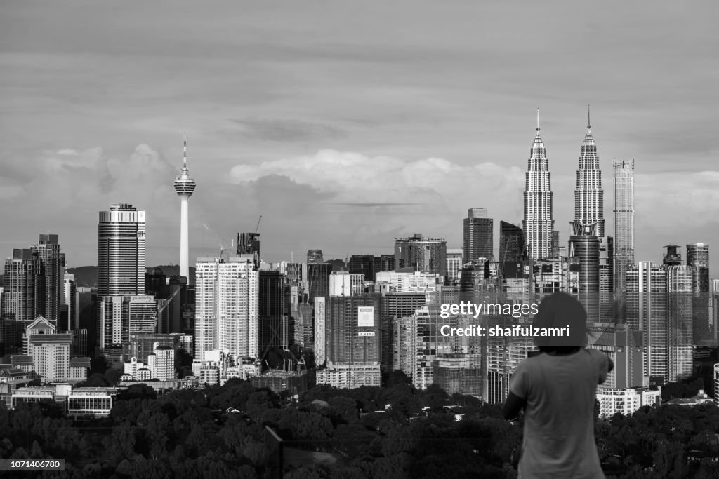 Unidentified tourist shots a picture of morning light over downtown Kuala Lumpur, Malaysia.