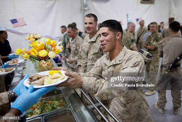 Marines get served turkey dinners in the main dining facility during the annual Thanksgiving meal at Camp Leatherneck, November 25, 2010 in Helmand,...