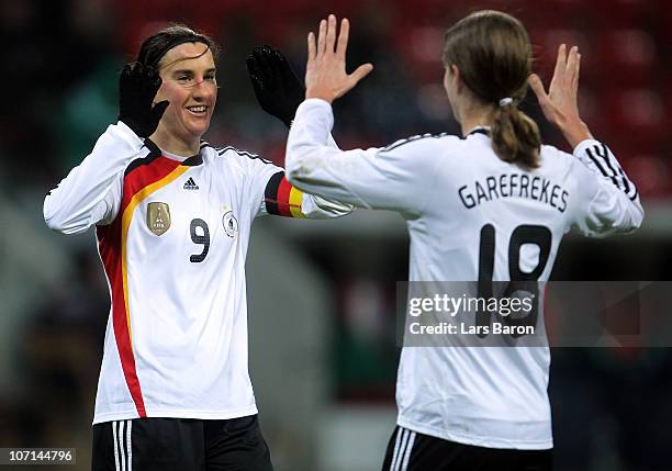 Birgit Prinz of Germany celebrates with Kerstin Garefrekes after scoring her team's fourth goal during the women's international friendly match...