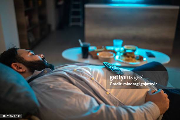 lazy man fell asleep in living room - fat guy belly stock pictures, royalty-free photos & images