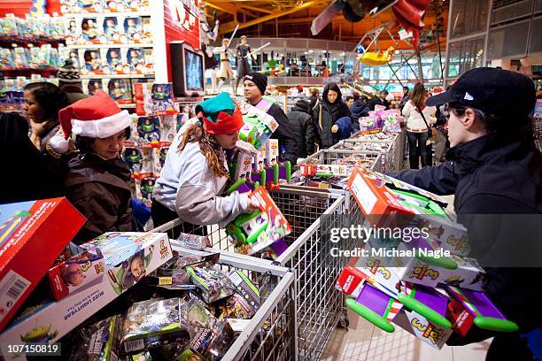 An employee helps shoppers with Toy Story 3 toys at Toys"R"Us on Thanksgiving Day, November 25 in New York City. The stores, which opened nationwide...