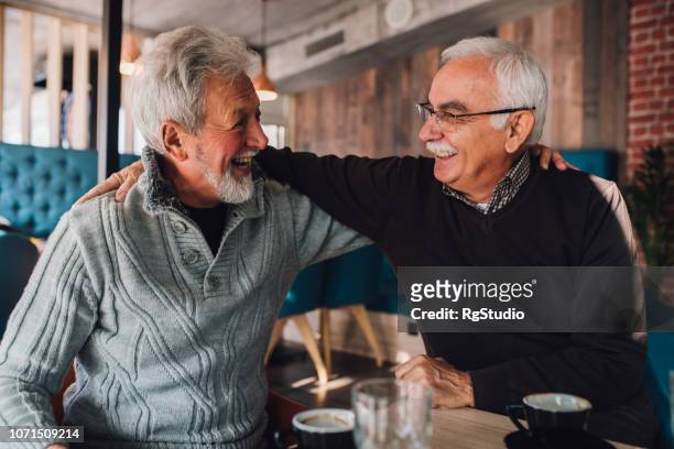 smiling old men hugging - only senior men stock pictures, royalty-free photos & images