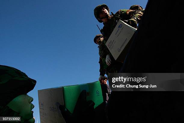 South Korean marines carry the necessaries from a boat at the port on November 26, 2010 in Yeonpyeong Island, South Korea. South Korean Prime...