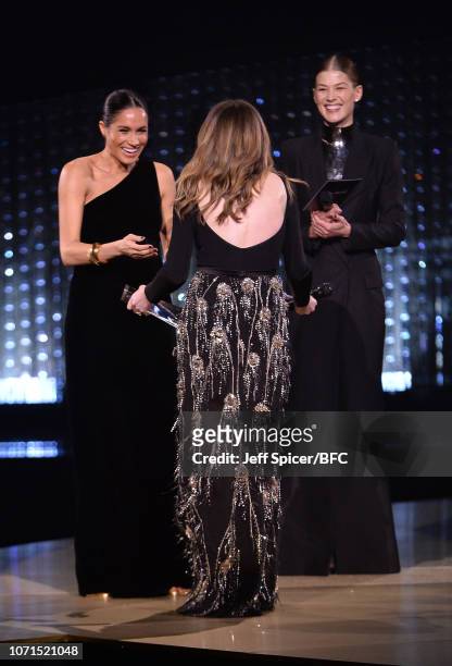 Meghan, Duchess of Sussex and Rosamund Pike present the award for British Designer of the Year Womenswear Award to Clare Waight Keller for Givenchy...