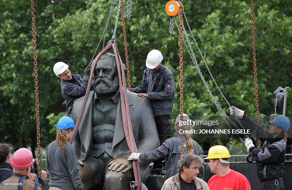 Workers lift a statue of German philosop