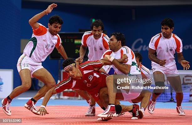 Anup Kumar of India captures Meisam Abbasi of Iran as he tries to raid for points during the Men's Kabaddi final at Nansha Gymnasium during day...