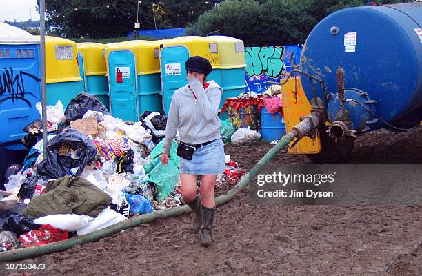 Girl holds her nose from the stench of rubbish and toilets in the mud, after a thunderous night of heavy rain during the Glastonbury Music Festival...