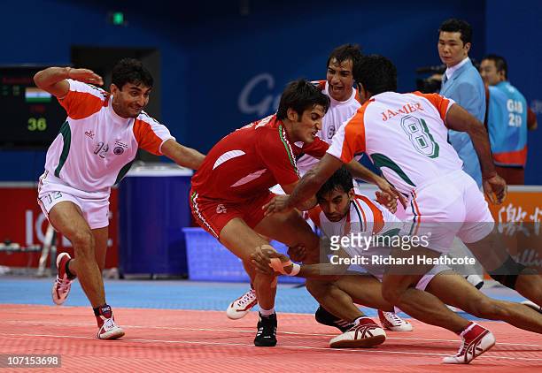 India capture Naser Roomiani Nazari of Iran as he tries to raid for points during the Men's Kabaddi final at Nansha Gymnasium during day fourteen of...