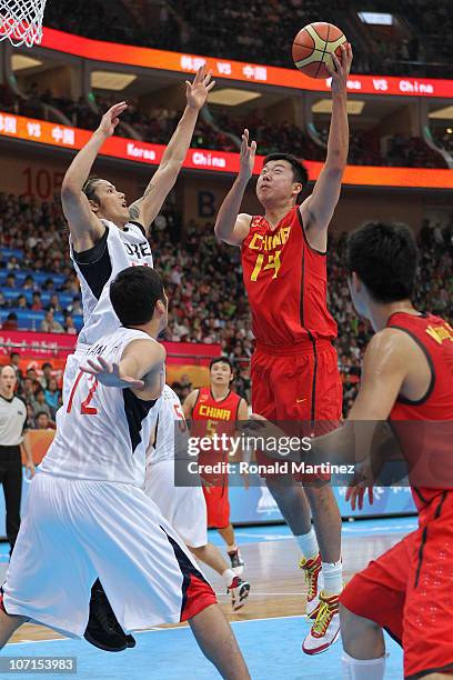 Wang Zhizhi of China shoots over Seung Jun Lee of South Korea in the second half during the men's gold medal basketball game at the Guangzhou...