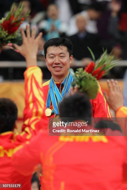 Wang Zhizhi of China is given all the medals as by his teammates as they bow to him after China wins the gold medal by defeating South Korea 77-71 in...