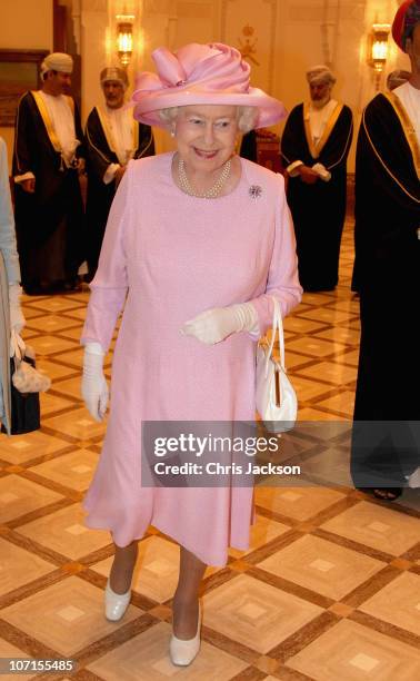 Queen Elizabeth II laughs as she attends a Tate Gallery event at Al-Alam Palace on November 26, 2010 in Muscat, Oman. Queen Elizabeth II and Prince...