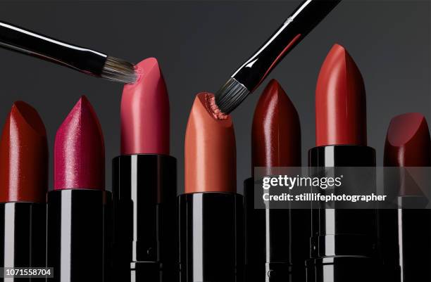 lipsticks in line with 2 brushes scraping - human mouth stock photos et images de collection