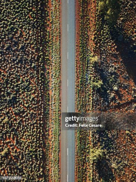 an aerial shot of the red centre roads in the australian outback - kings canyon australia stockfoto's en -beelden