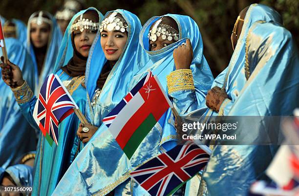 People wait for the arrival of Queen Elizabeth II and Prince Philip, Duke of Edinburgh to be officially welcomed by the Sultan Qaboos bin Said at the...